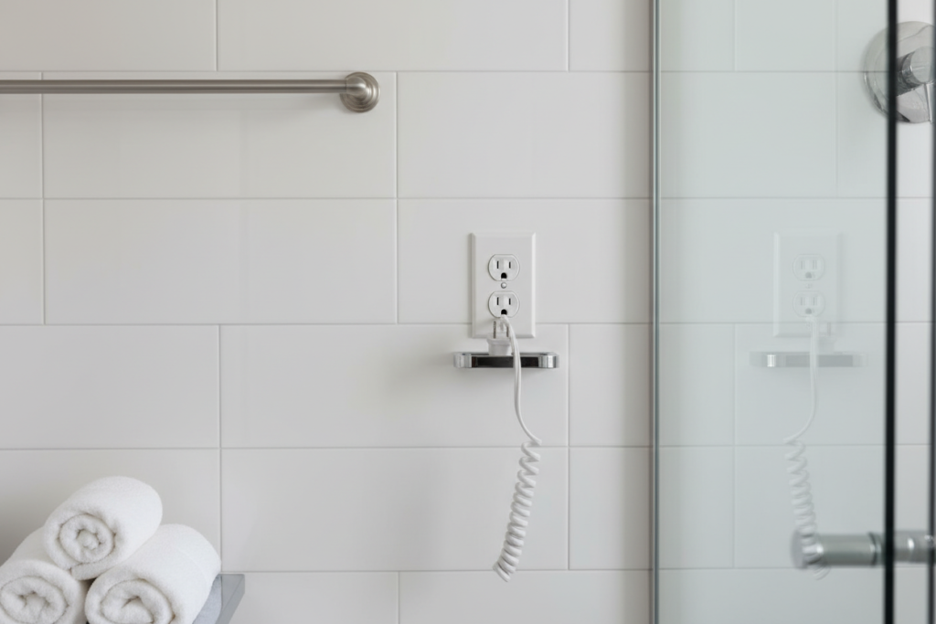 A bathroom with a convenient outlet for a plug-in towel warmer